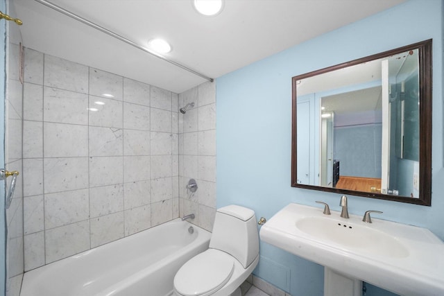 full bathroom featuring sink, toilet, and tiled shower / bath