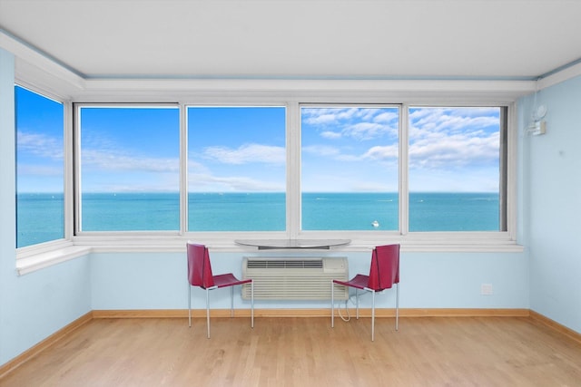 unfurnished sunroom featuring a water view and an AC wall unit