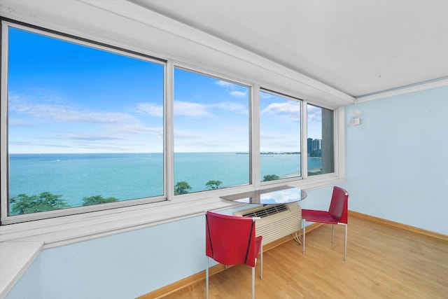 sunroom / solarium featuring a water view