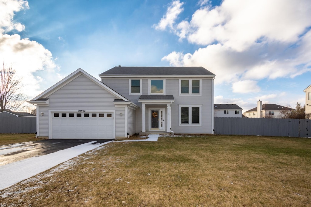 view of property featuring a front lawn and a garage