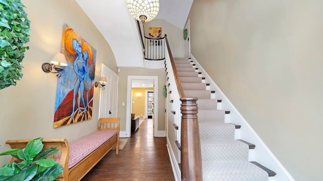 entryway with dark wood-type flooring and a notable chandelier