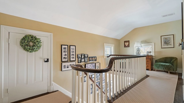 carpeted entryway with vaulted ceiling