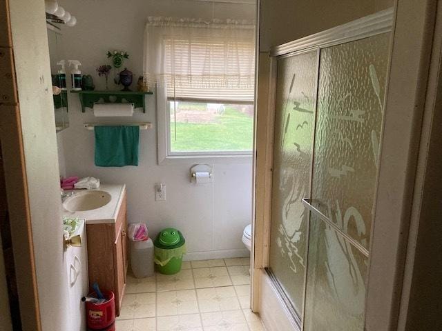 full bathroom with shower / bath combination with glass door, vanity, toilet, and a healthy amount of sunlight