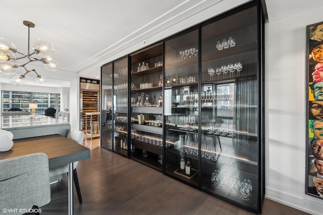 bar with dark wood-type flooring and a chandelier