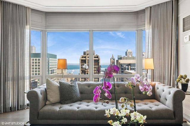 living room with crown molding, a water view, and plenty of natural light