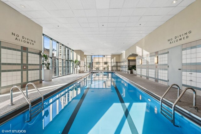 workout area featuring a drop ceiling and dark wood-type flooring