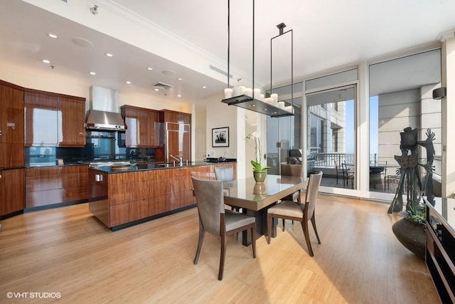 dining space with sink, ornamental molding, and light hardwood / wood-style flooring