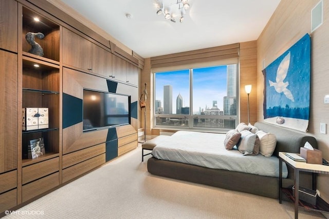 carpeted bedroom featuring wood walls and an inviting chandelier