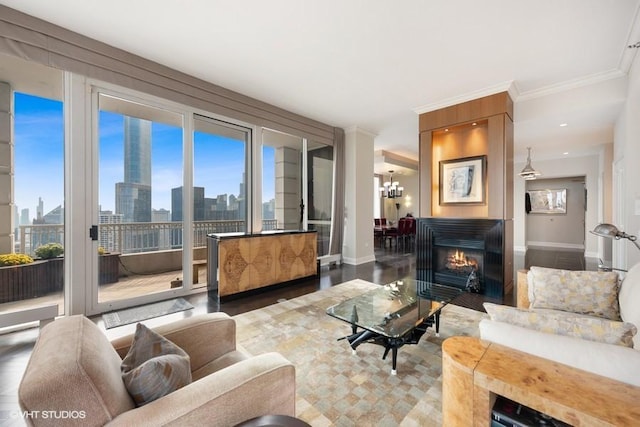 living room with plenty of natural light, a large fireplace, crown molding, and an inviting chandelier