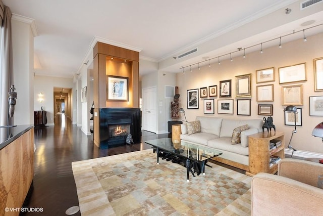 living room featuring track lighting, crown molding, and dark hardwood / wood-style flooring