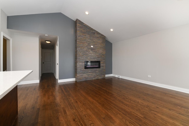 unfurnished living room featuring high vaulted ceiling, dark hardwood / wood-style floors, and a stone fireplace