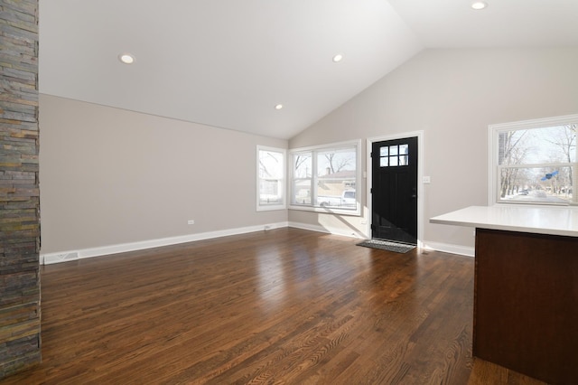 entryway with dark wood-type flooring and high vaulted ceiling