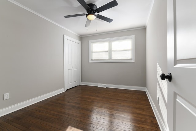 empty room with ceiling fan, dark hardwood / wood-style floors, and crown molding