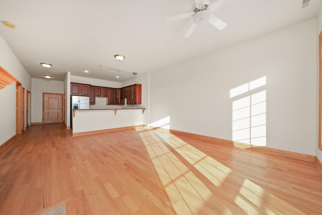 unfurnished living room with ceiling fan and light hardwood / wood-style floors