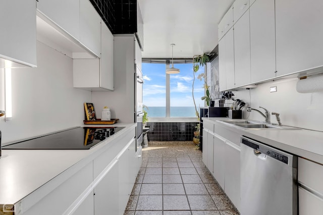 kitchen featuring pendant lighting, dishwasher, sink, white cabinets, and a water view