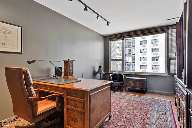 home office with track lighting and light wood-type flooring