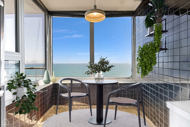 sunroom / solarium featuring a water view