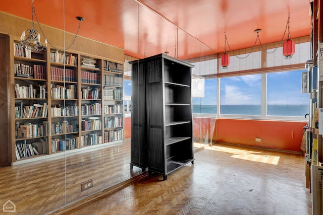 miscellaneous room featuring a water view and parquet flooring