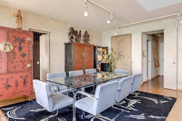 dining area with rail lighting and parquet flooring