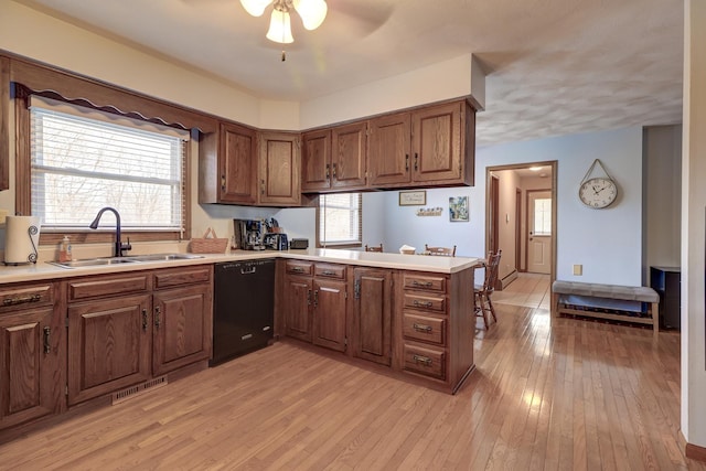 kitchen with sink, light hardwood / wood-style flooring, dishwasher, kitchen peninsula, and ceiling fan