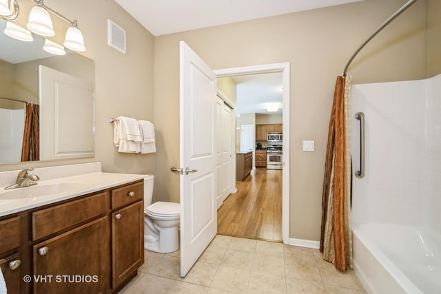 full bathroom featuring tile patterned floors, toilet, shower / bath combo with shower curtain, and vanity