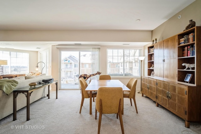 dining area featuring a wealth of natural light and light colored carpet