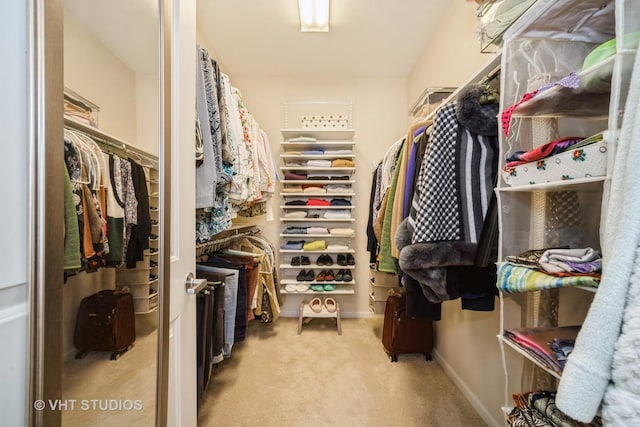 spacious closet featuring light colored carpet