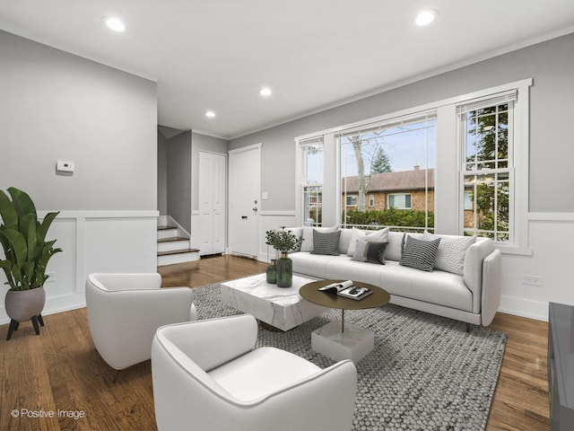 living area with recessed lighting, wood finished floors, and a wainscoted wall