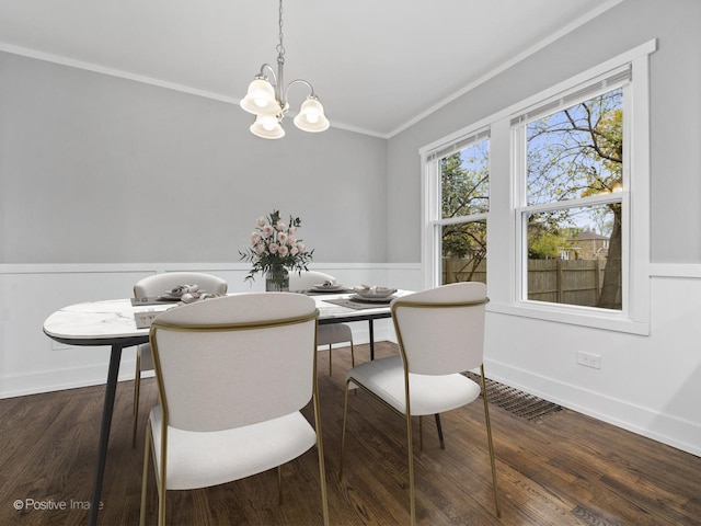 dining space with visible vents, crown molding, wainscoting, an inviting chandelier, and wood finished floors