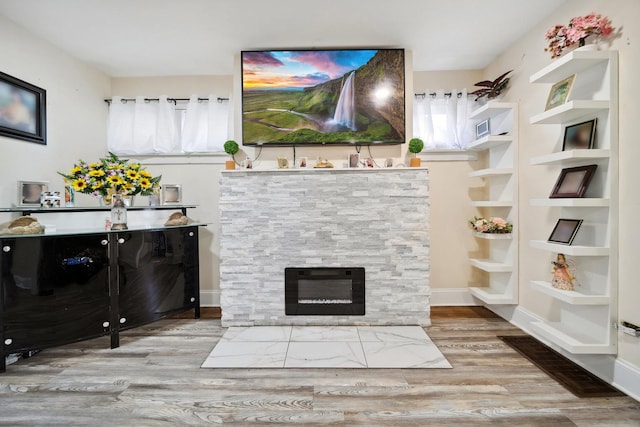 interior space with light hardwood / wood-style flooring and a stone fireplace