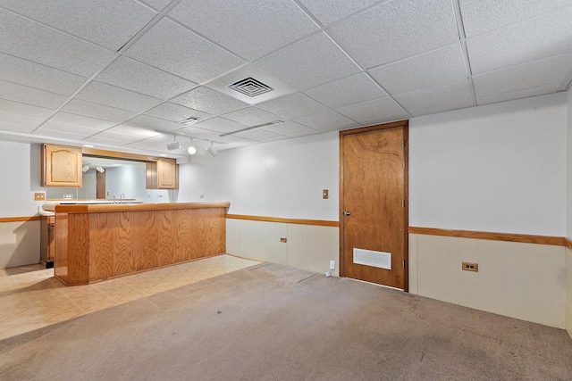 bar with rail lighting, light carpet, and a drop ceiling