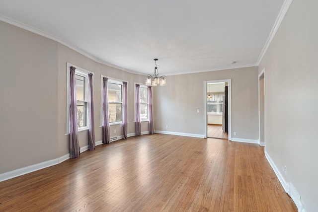 unfurnished room featuring wood-type flooring, ornamental molding, and a chandelier