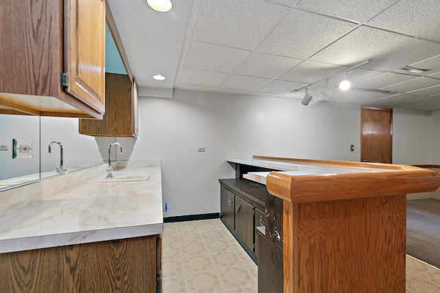 kitchen featuring rail lighting, sink, and a paneled ceiling