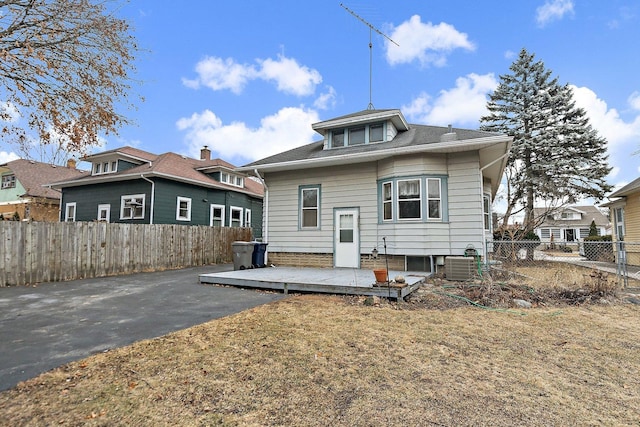 rear view of house featuring a wooden deck, a yard, and central air condition unit