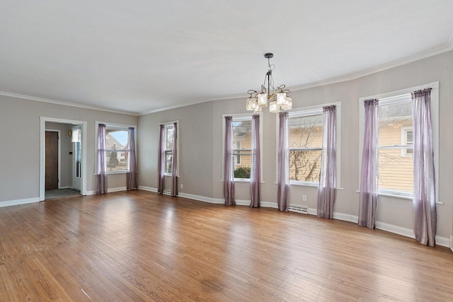 unfurnished room with a notable chandelier, crown molding, and light hardwood / wood-style flooring