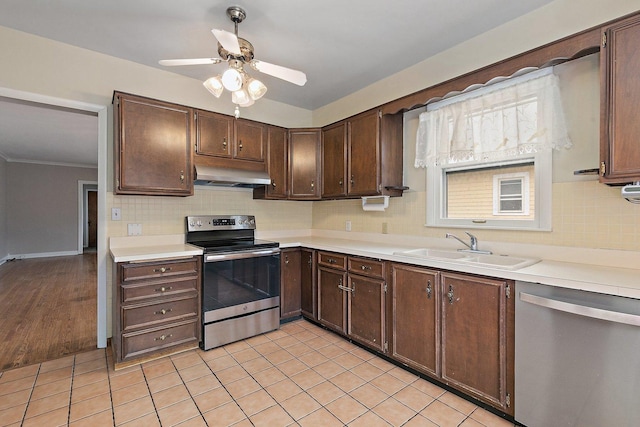 kitchen featuring tasteful backsplash, dark brown cabinetry, stainless steel appliances, and sink