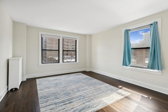 unfurnished room with dark wood-type flooring