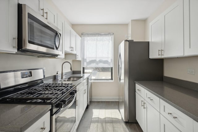 kitchen featuring sink, white cabinetry, appliances with stainless steel finishes, and dark hardwood / wood-style flooring