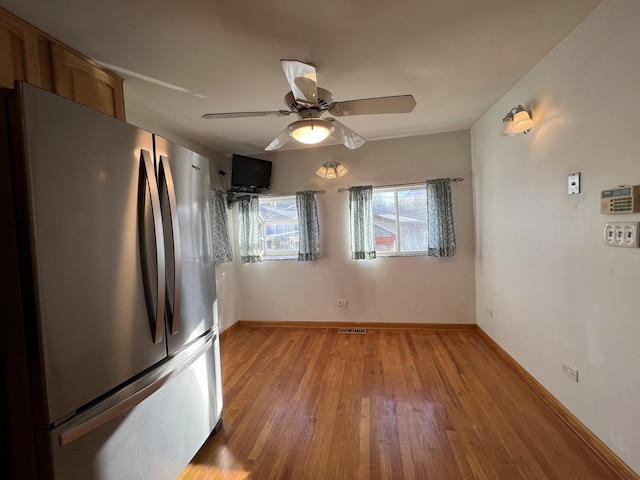 kitchen featuring ceiling fan, hardwood / wood-style floors, and stainless steel refrigerator