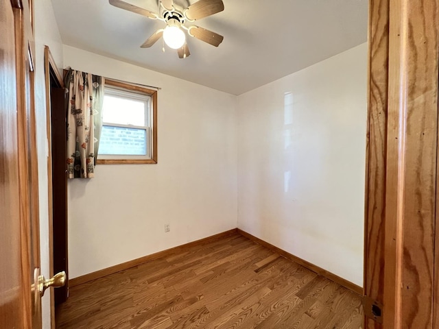 empty room with ceiling fan and hardwood / wood-style flooring