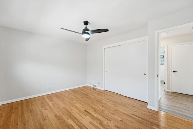 empty room with ceiling fan and light hardwood / wood-style flooring