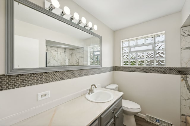 bathroom with toilet, vanity, walk in shower, and hardwood / wood-style flooring