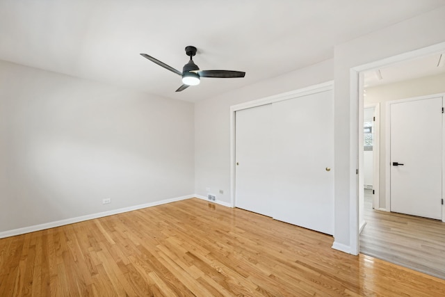 empty room with ceiling fan and light hardwood / wood-style flooring