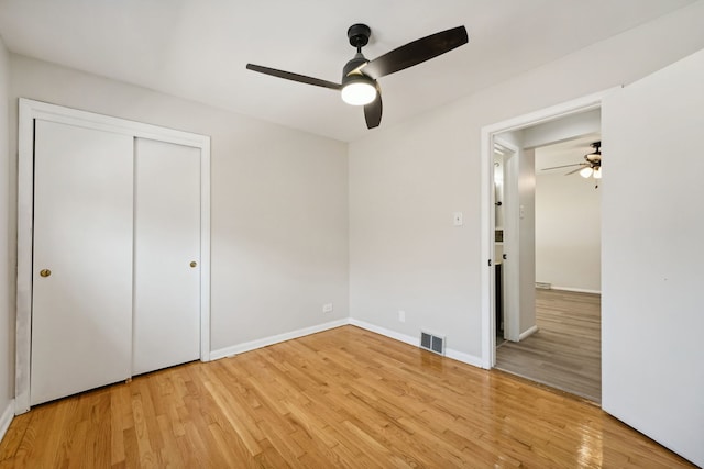 unfurnished bedroom featuring ceiling fan, a closet, and light hardwood / wood-style floors