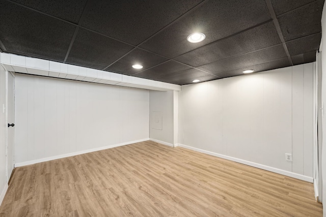 basement with light hardwood / wood-style floors and a drop ceiling