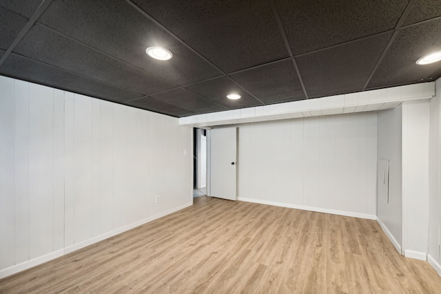 basement featuring a drop ceiling and wood-type flooring