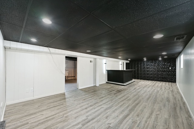 basement featuring wood-type flooring and a drop ceiling