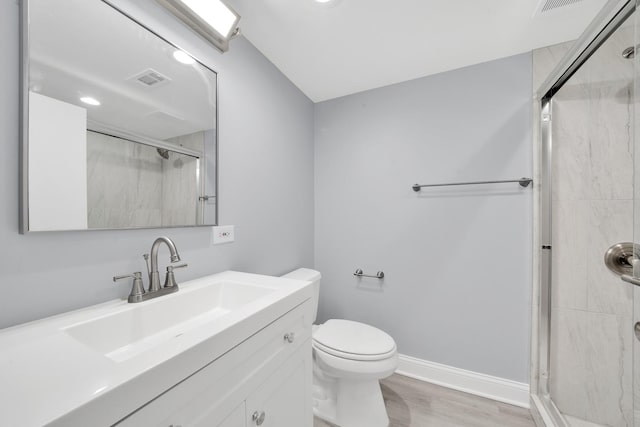 bathroom with hardwood / wood-style floors, an enclosed shower, vanity, and toilet