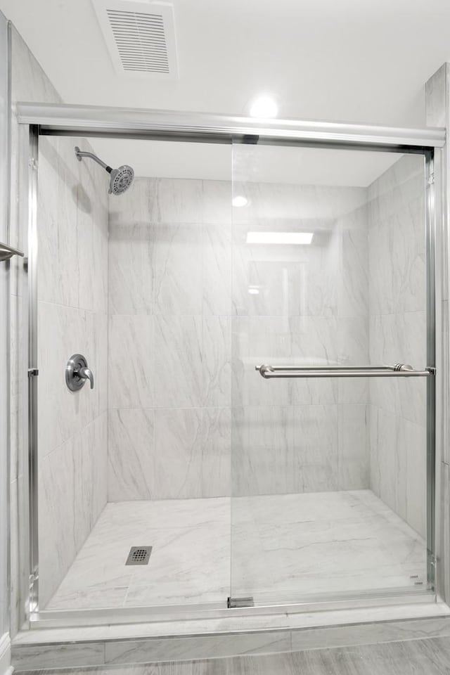 bathroom with a shower with door