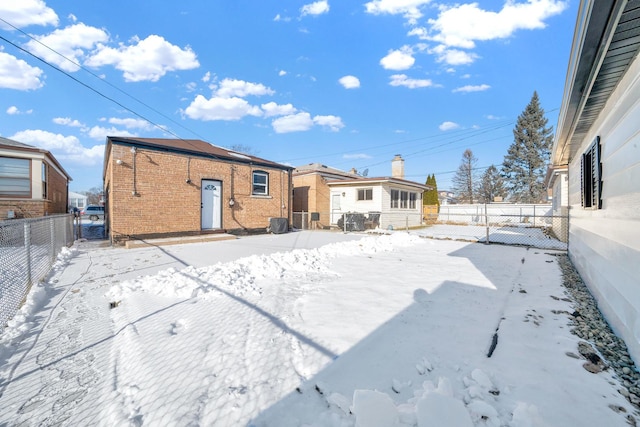 view of snow covered rear of property